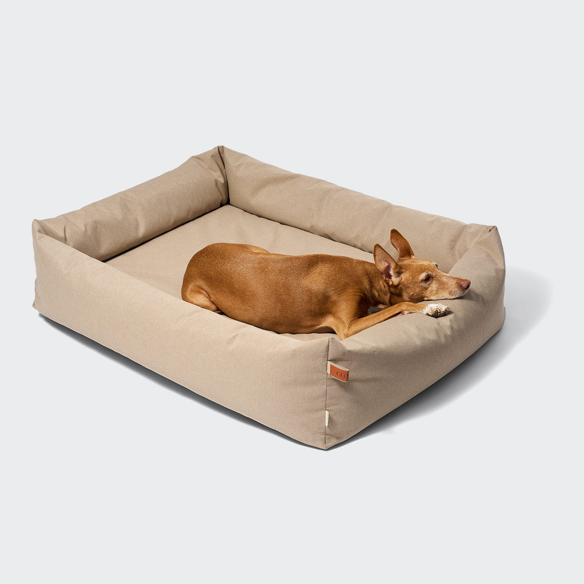 CLOUD7 Sleepy Deluxe indoor and outdoor dog bed with a waterproof cover and protective bolster rim in beige sand.